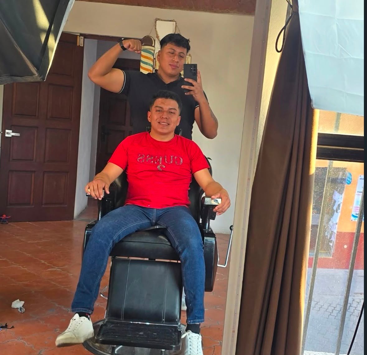 Barbero de Aesthetic Barber Studio junto a un cliente satisfecho en la silla