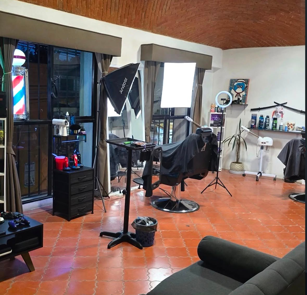 Estación de barbero con ring light, poste de barbero y decoración del estudio